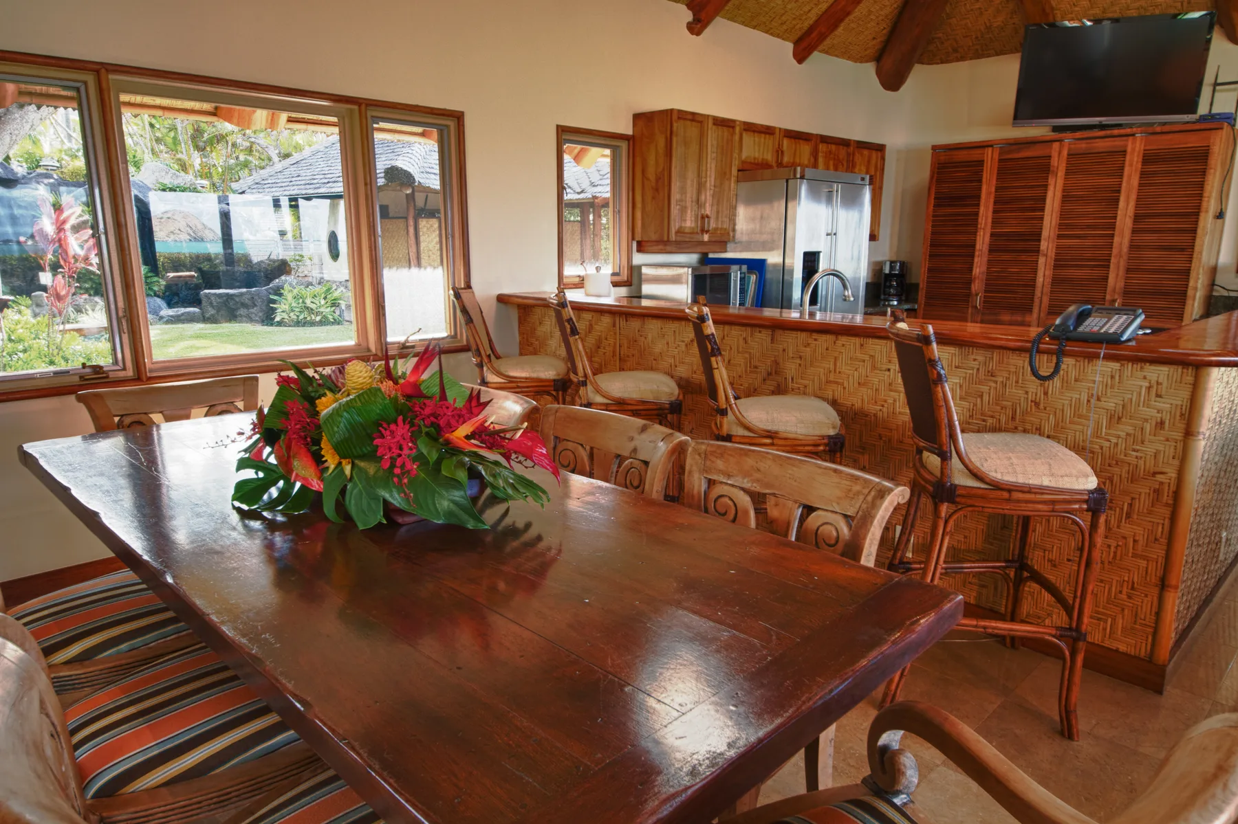 Un comedor con una mesa larga de madera y un centro floral.