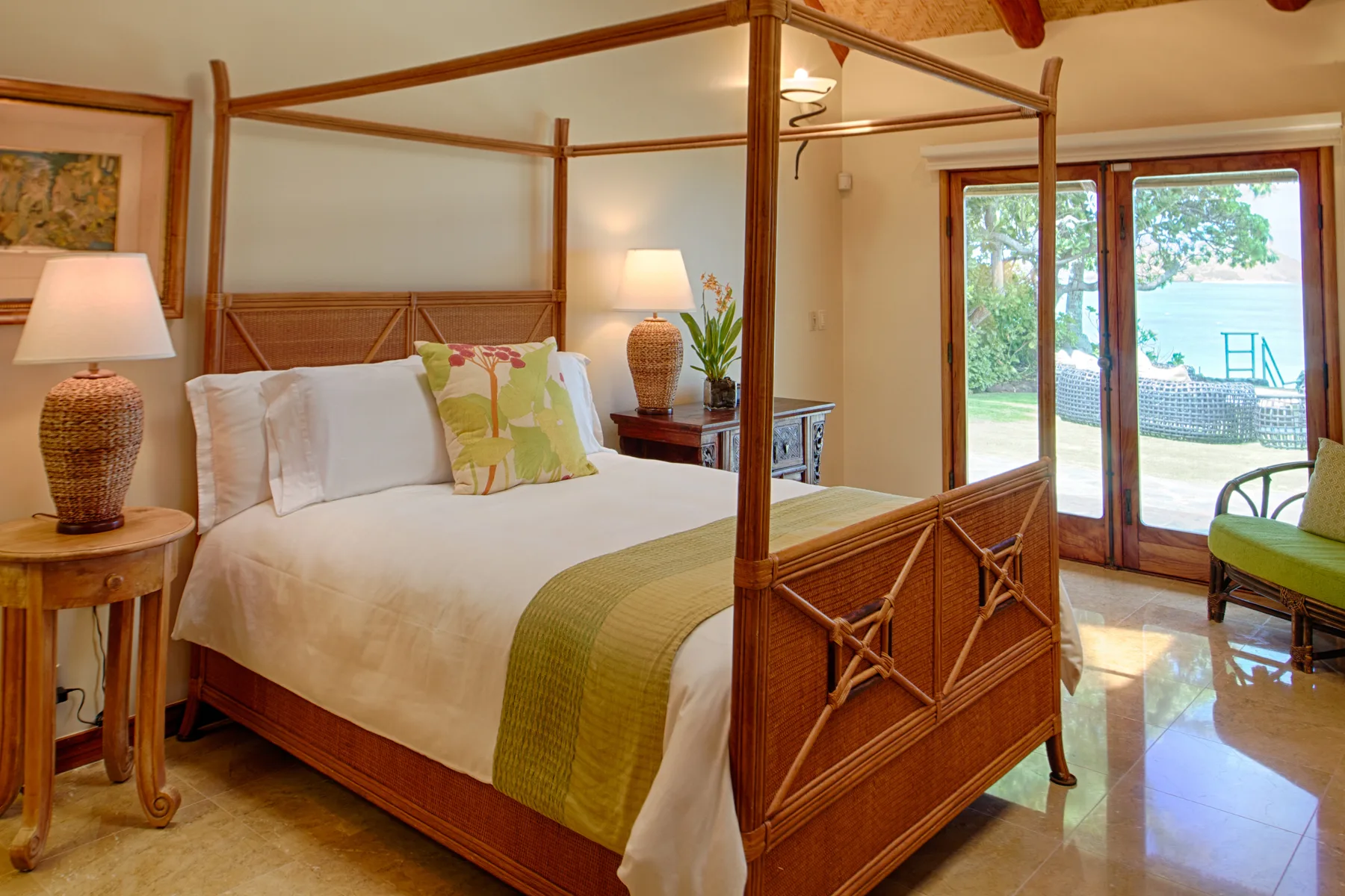 Un dormitorio con cama con dosel y puertas de vidrio que dan a un patio.