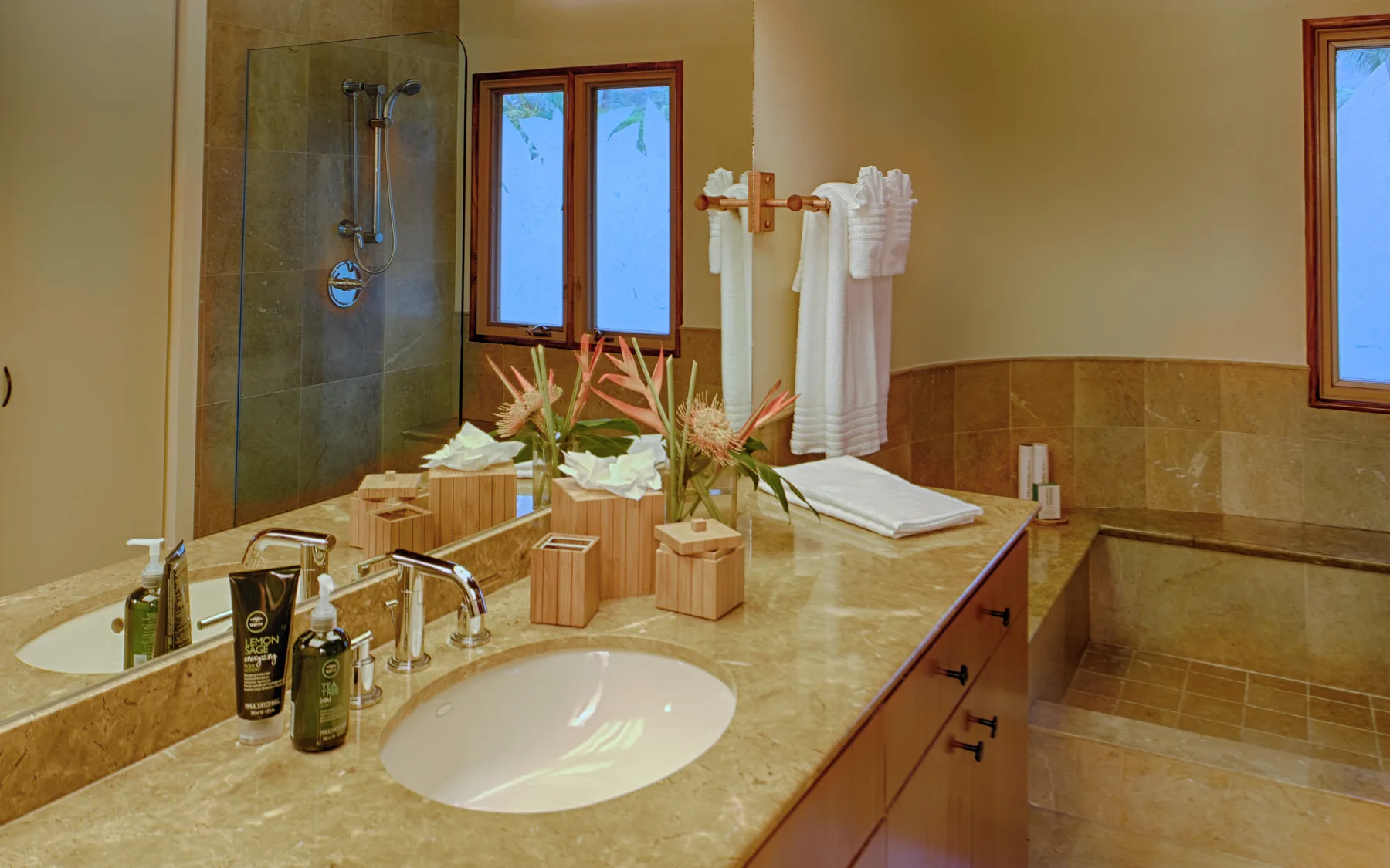Un lavabo de baño con un lavamanos y una ducha con mampara de vidrio.