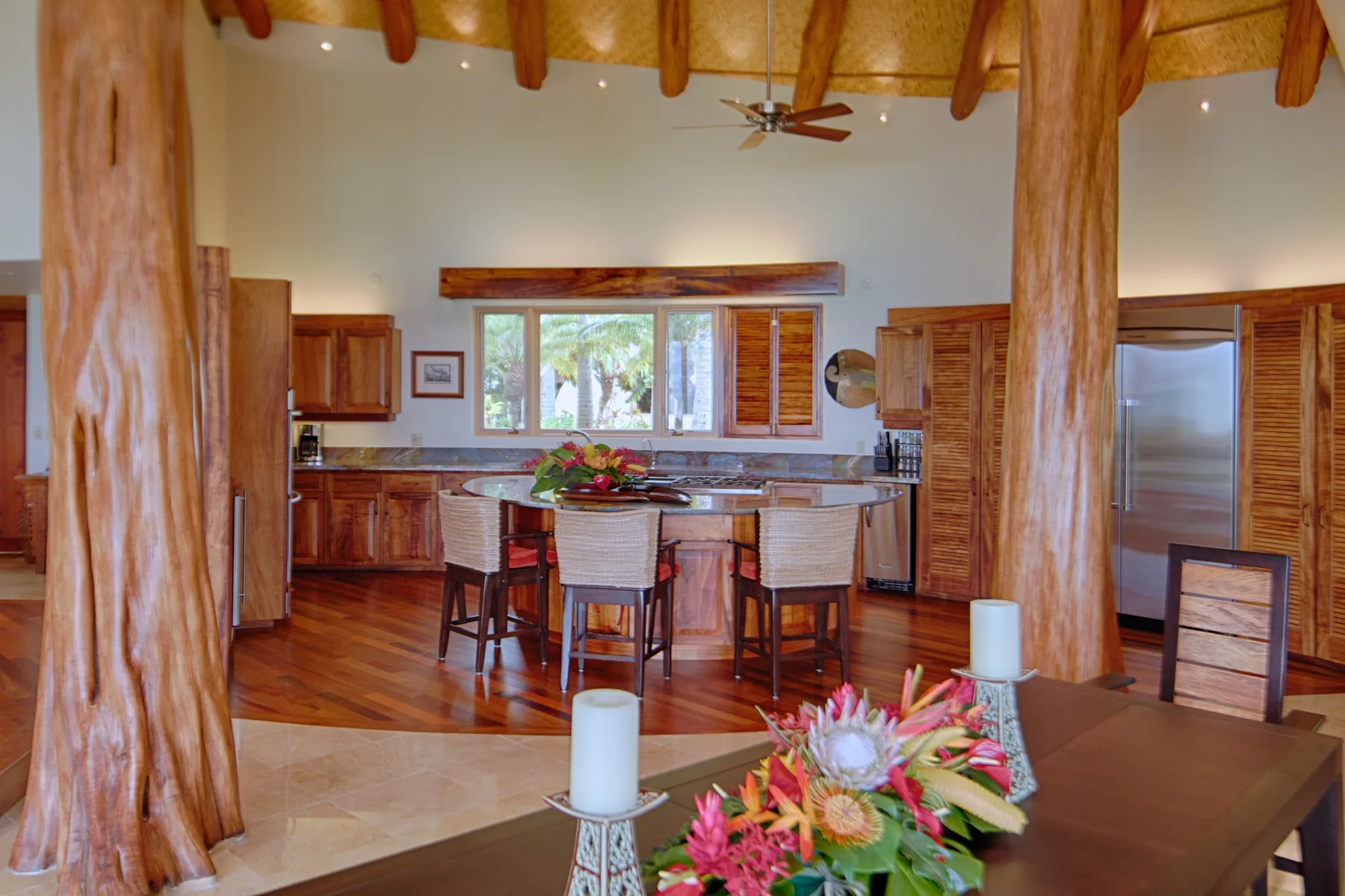 Una amplia cocina y comedor con gabinetes de madera y una mesa central.