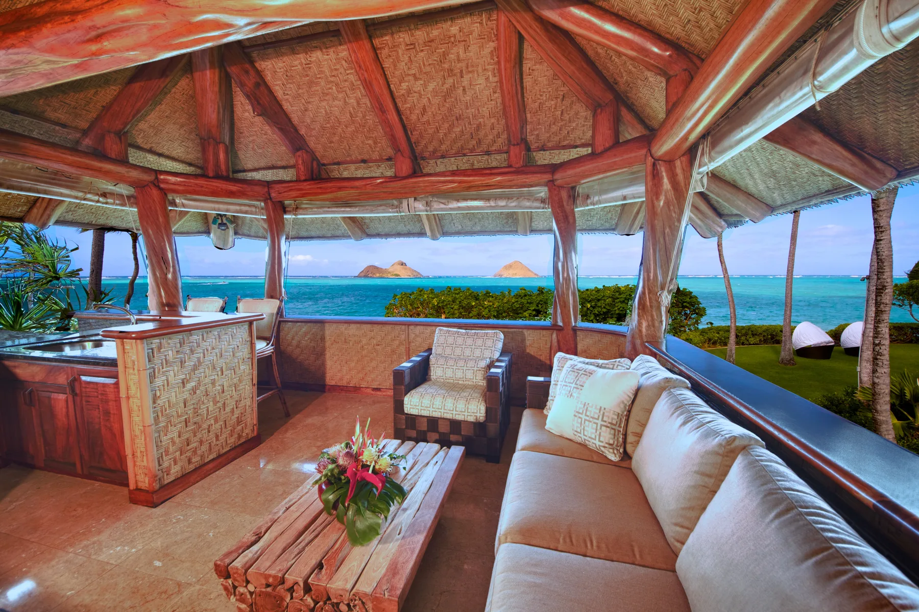 Un salón al aire libre con asientos y vista al mar.