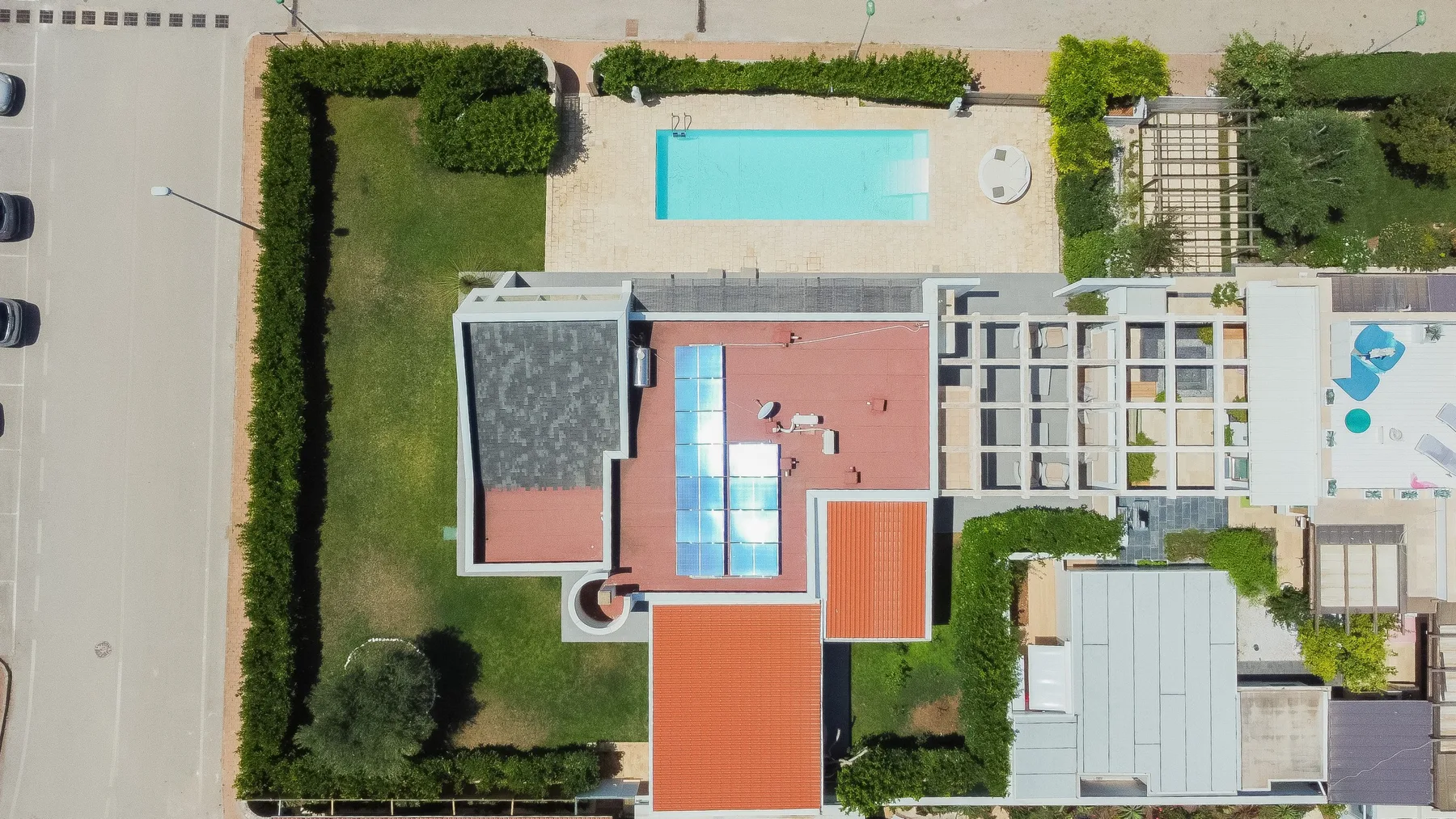 Una vista aérea muestra una casa, jardines y una piscina.