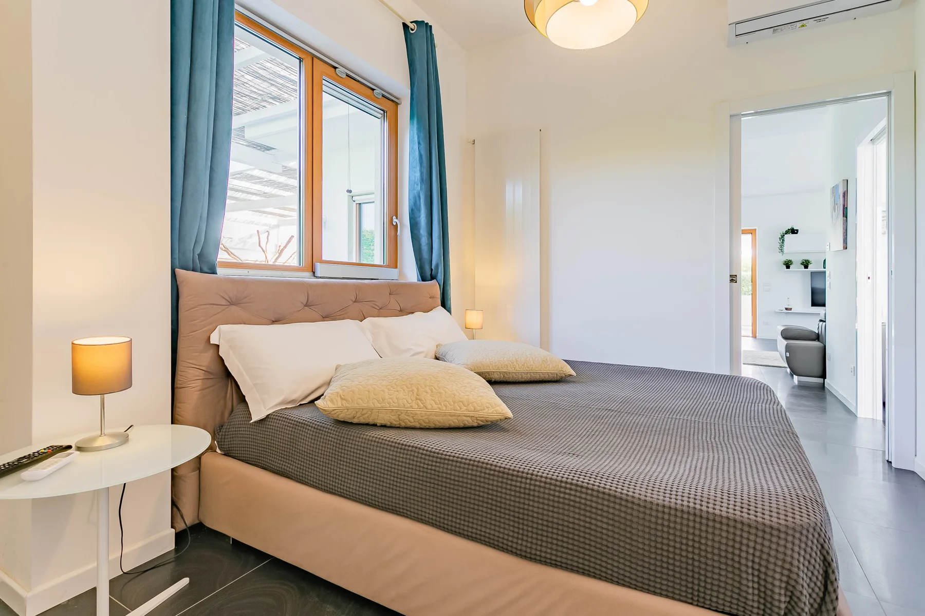Un dormitorio con una cama junto a una ventana con cortinas azules.