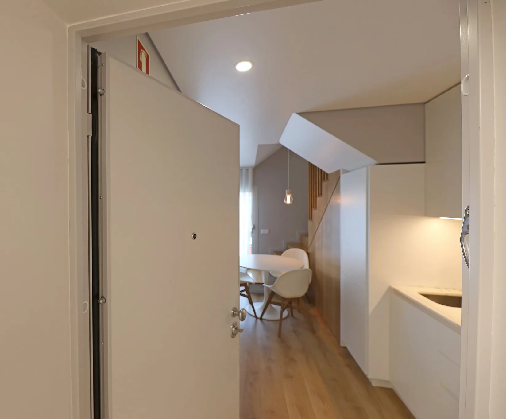 A compact apartment interior with a dining area beside a kitchenette.