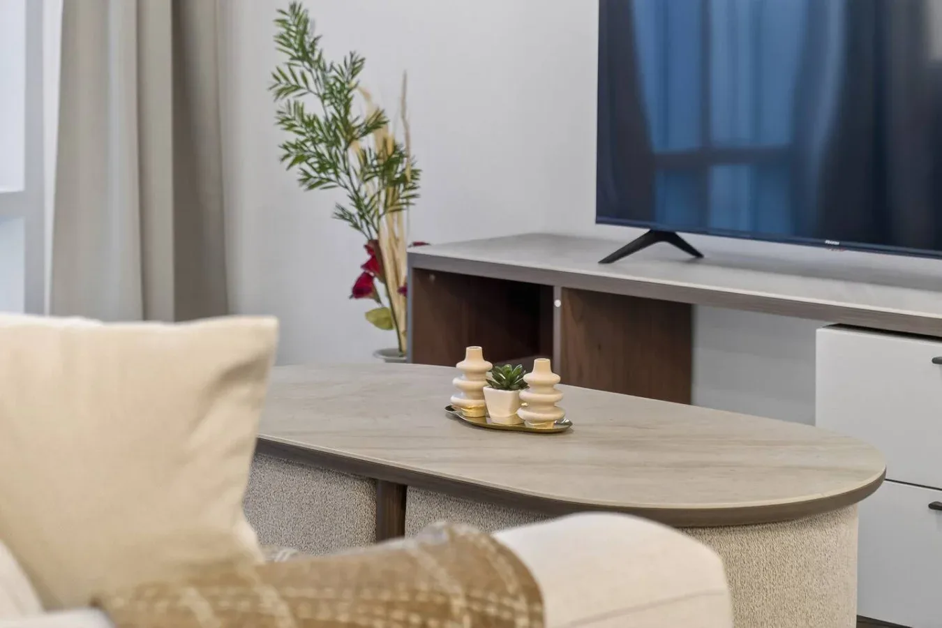 Una sala de estar con televisión, mesa de centro y asientos.