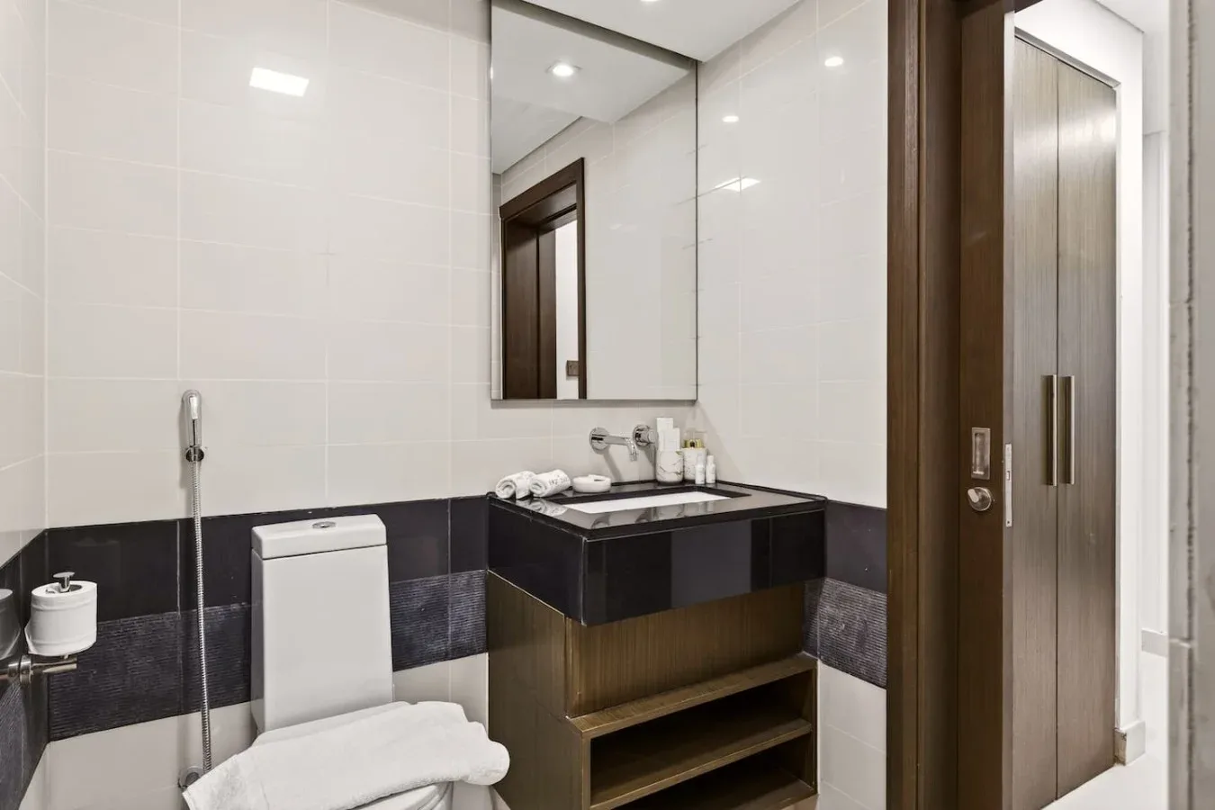 Un baño con azulejos, lavabo, espejo e inodoro.