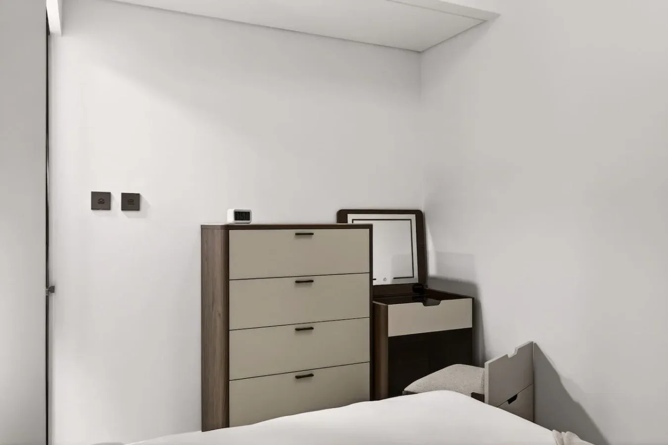 Un dormitorio con una cómoda alta y un escritorio.