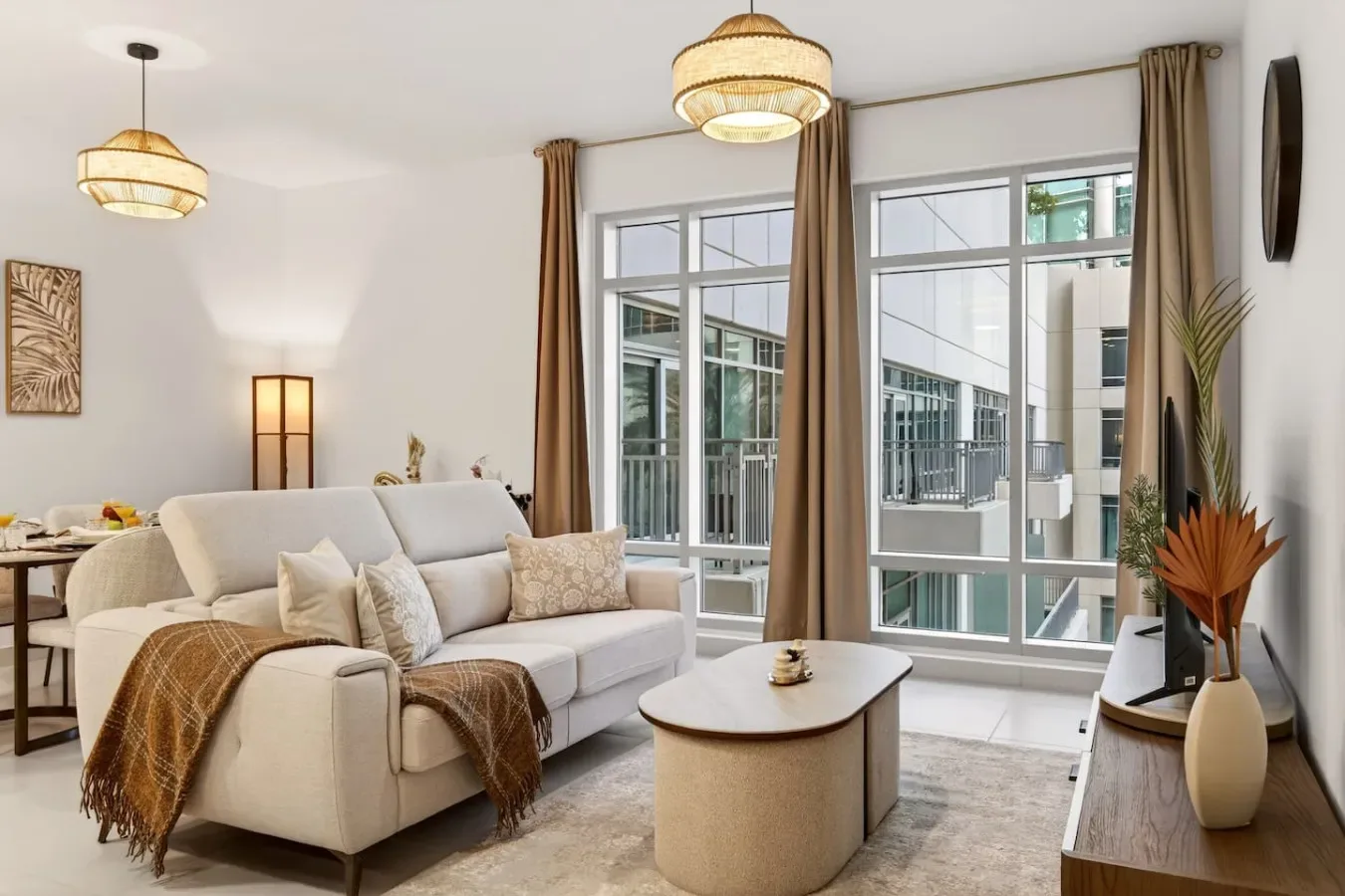 Una sala luminosa con asientos junto a grandes ventanas y cortinas largas.