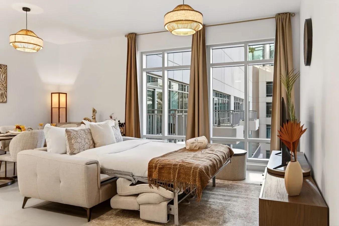 Un dormitorio luminoso con una cama grande y ventanales de piso a techo.