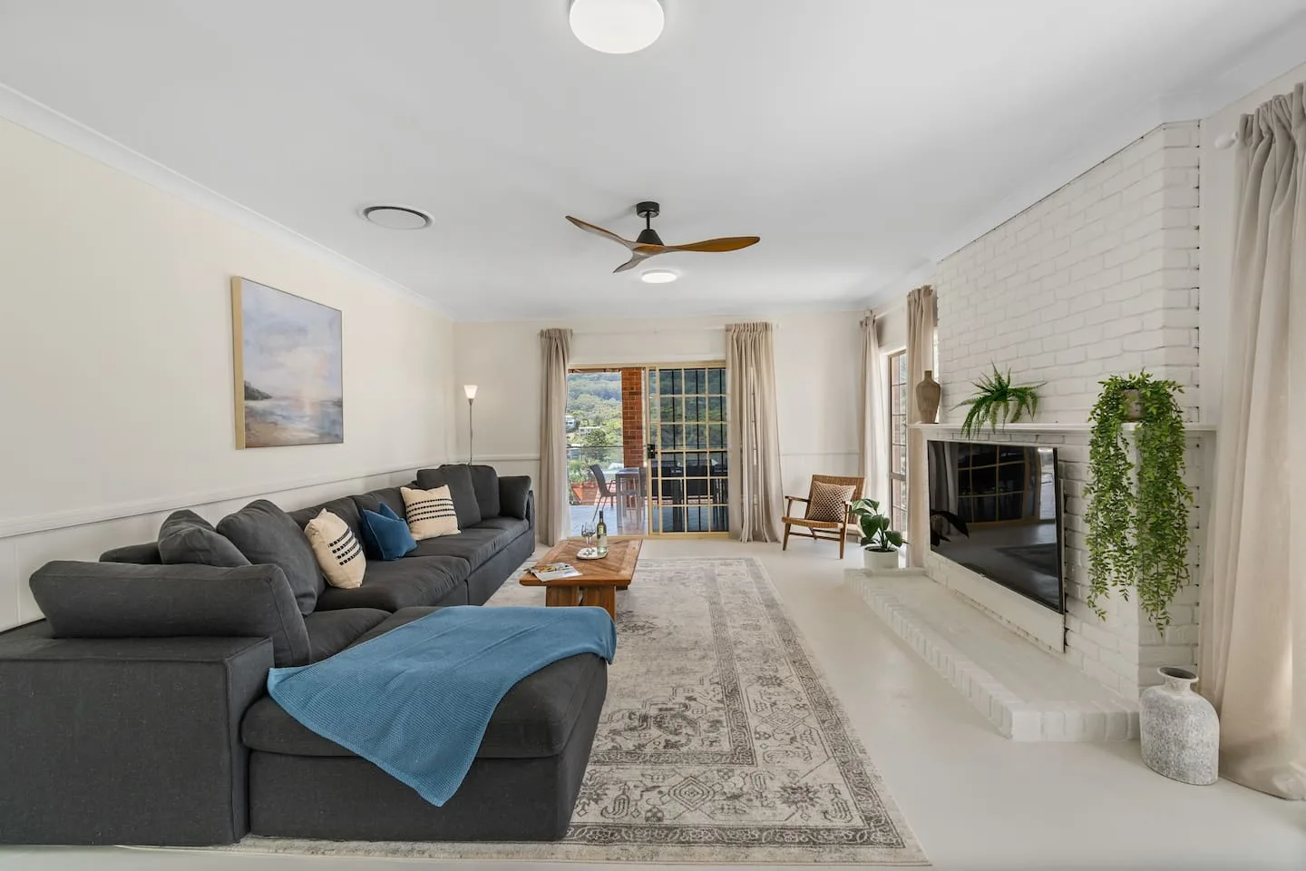 A living room with sectional seating, a rug, and a fireplace.