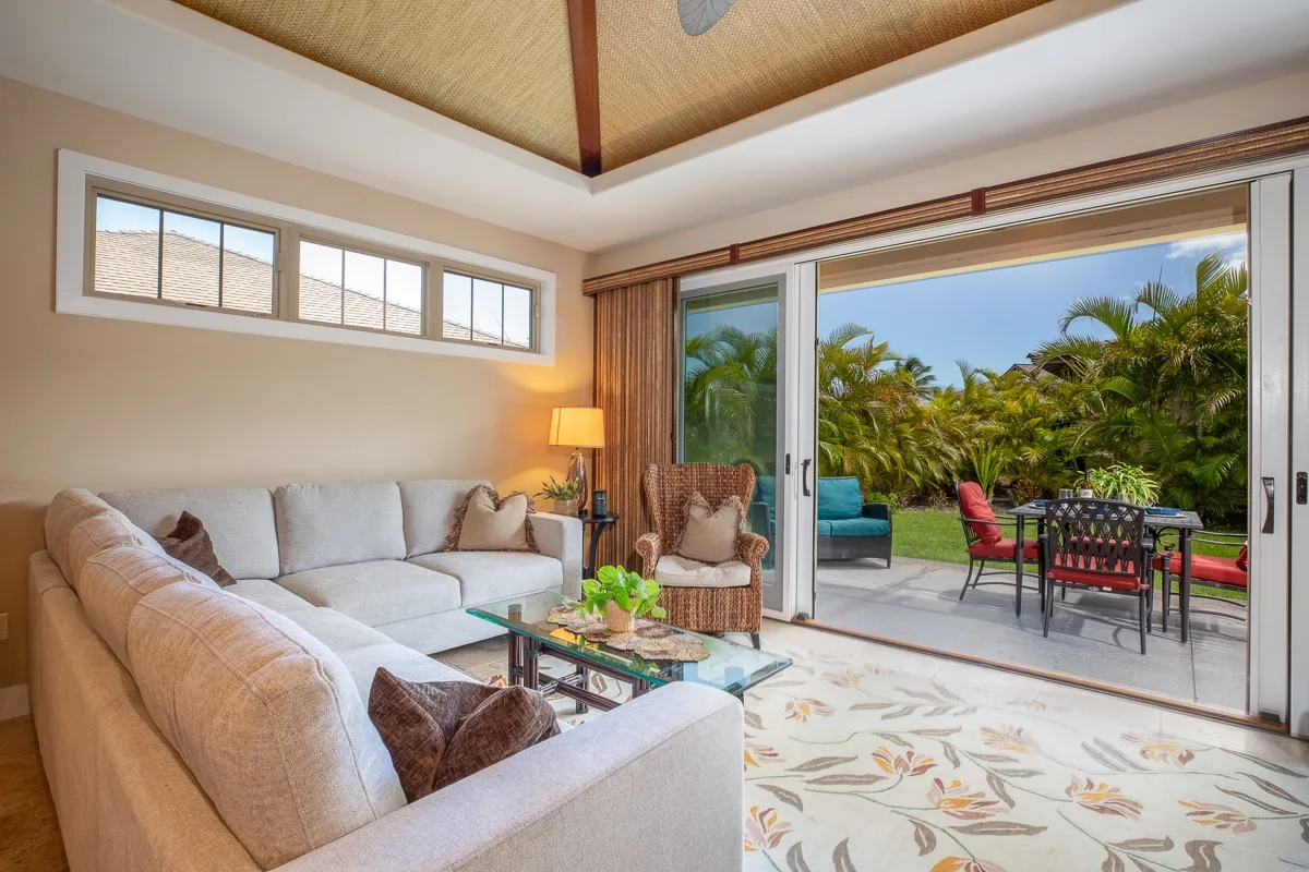 A living room with a sectional seating area opening onto a garden patio.