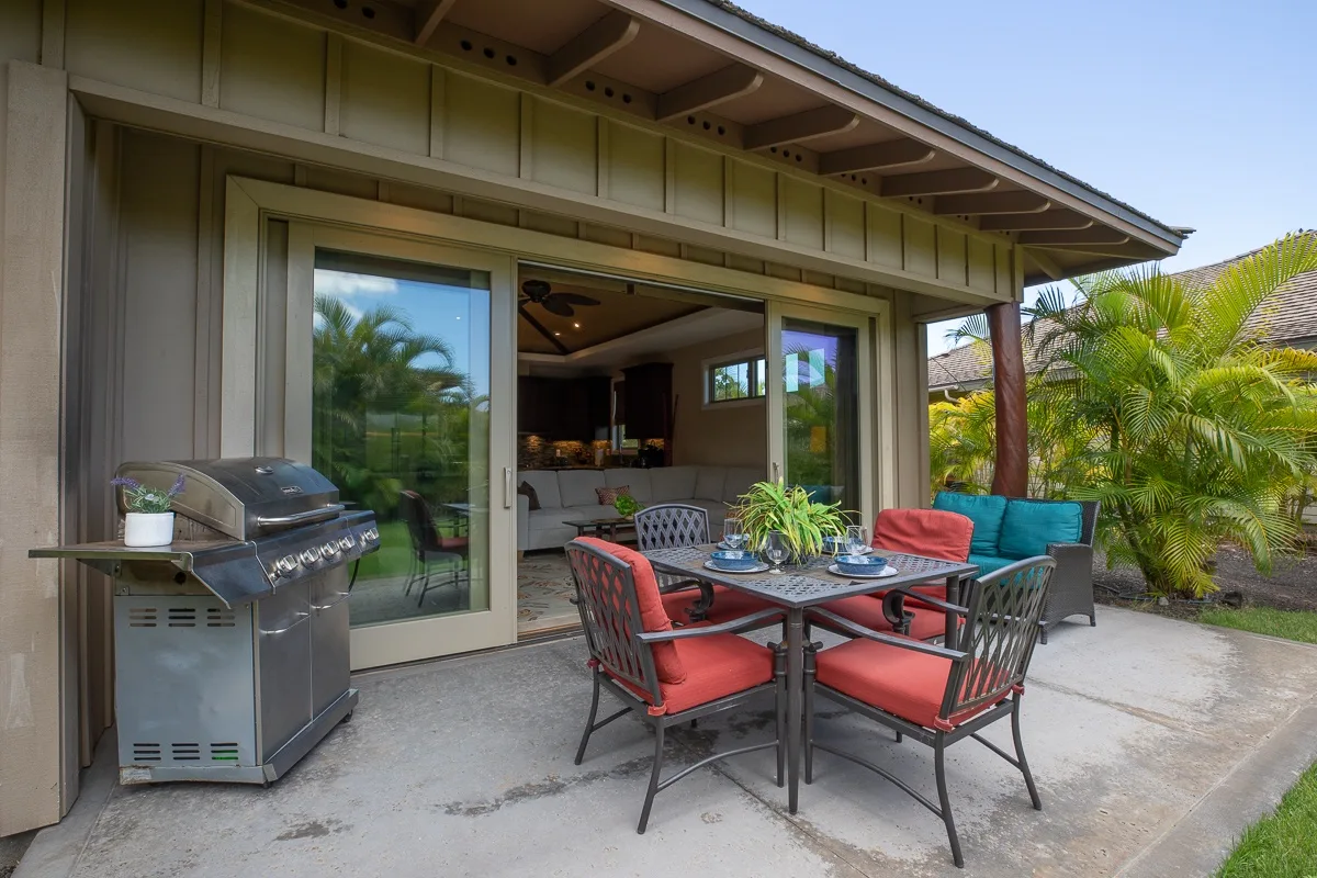 An outdoor dining patio with red-cushioned seating beside an open living area.