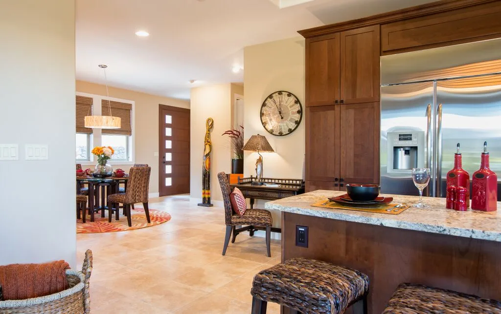 A warm-toned kitchen and dining area with a counter, seating, and a dining table.
