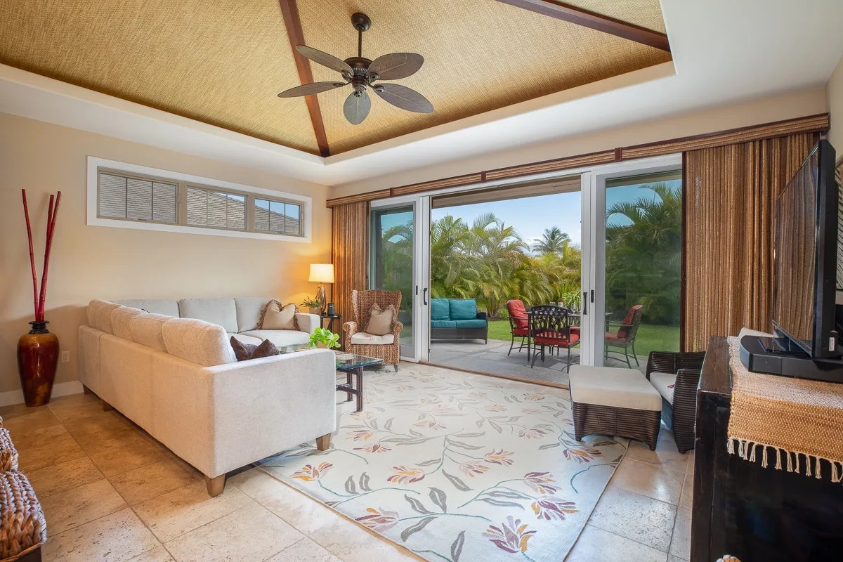 A living room opens onto a patio through wide glass doors.