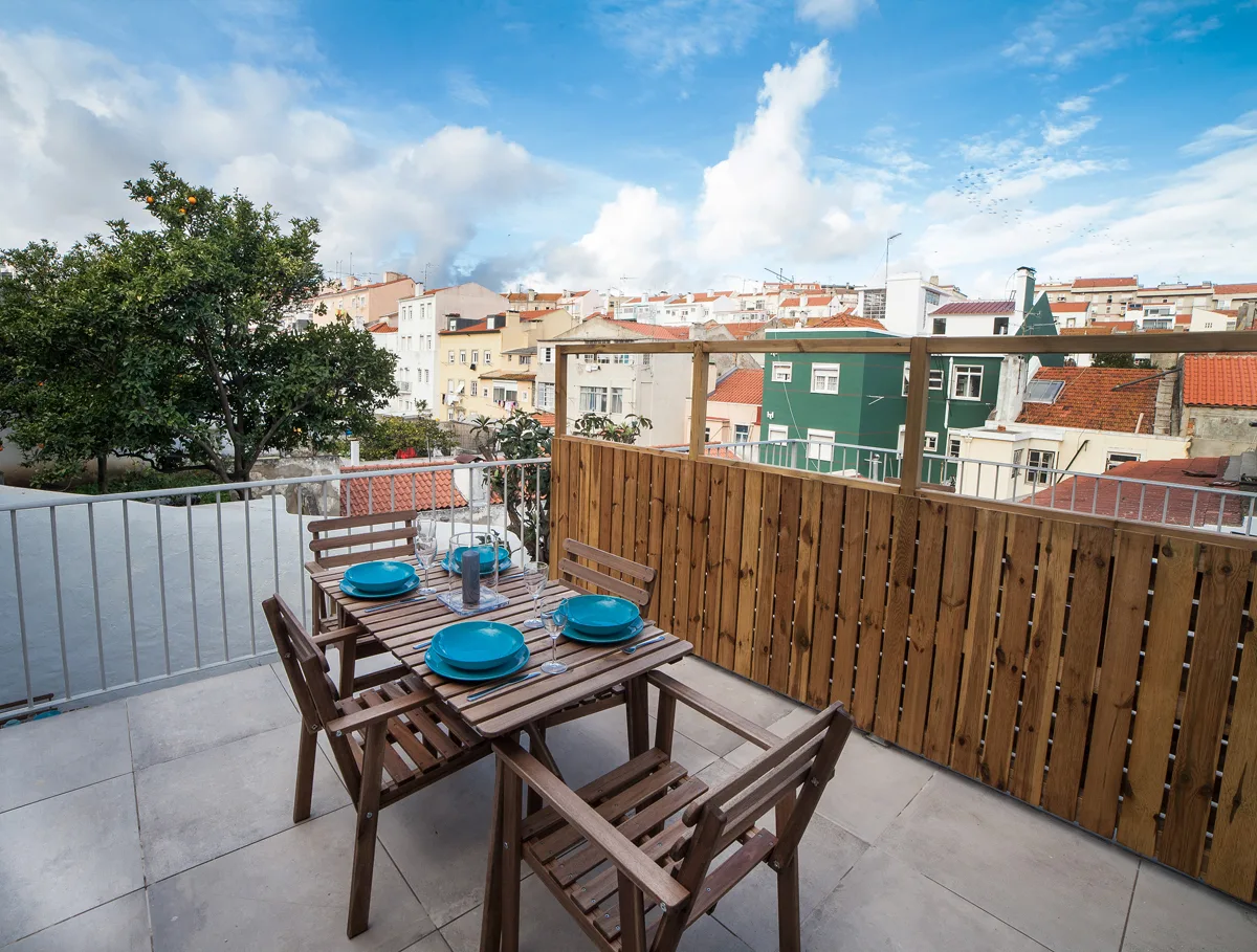 A rooftop terrace with outdoor seating and views of nearby buildings.