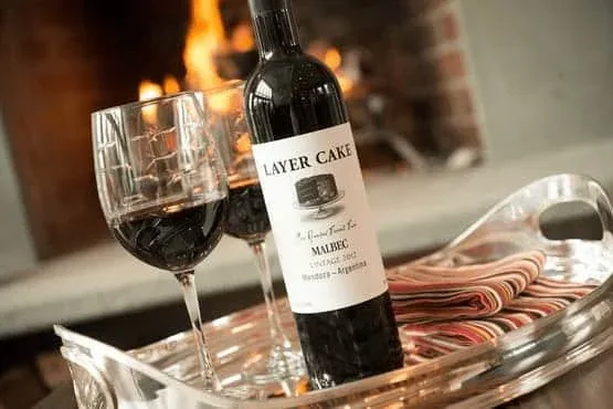 Huésped disfrutando de una copa de vino junto a la chimenea