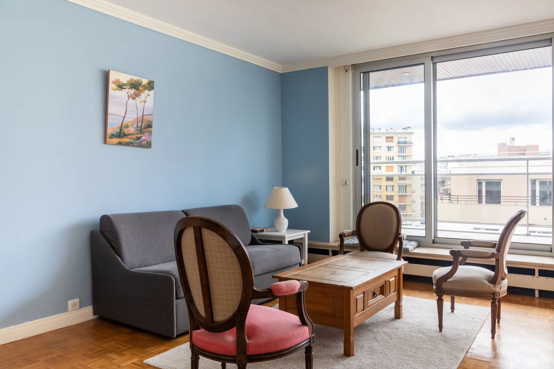 A blue-walled living room with seating around a wooden coffee table.