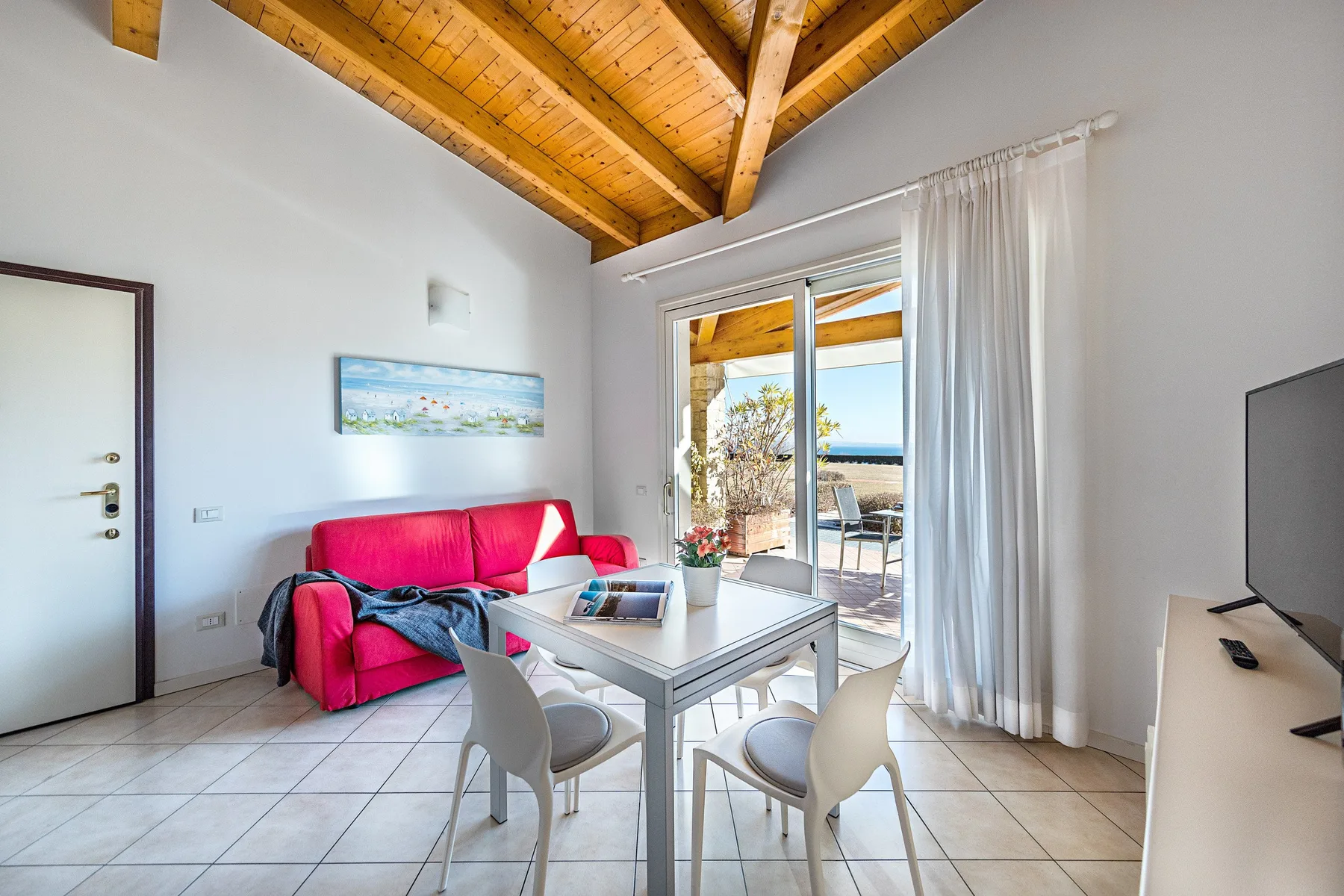 A bright living area with a dining table and sliding glass doors opening onto a patio.