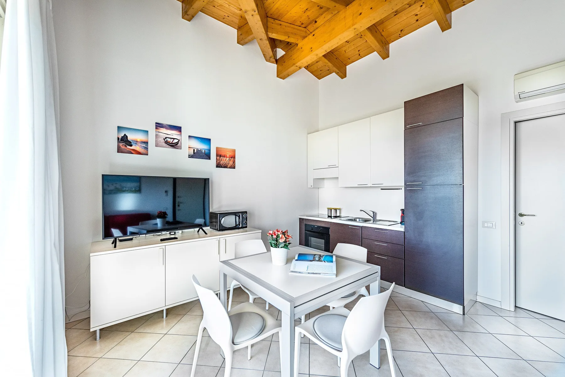 A bright kitchen and dining area with white cabinetry and a table.