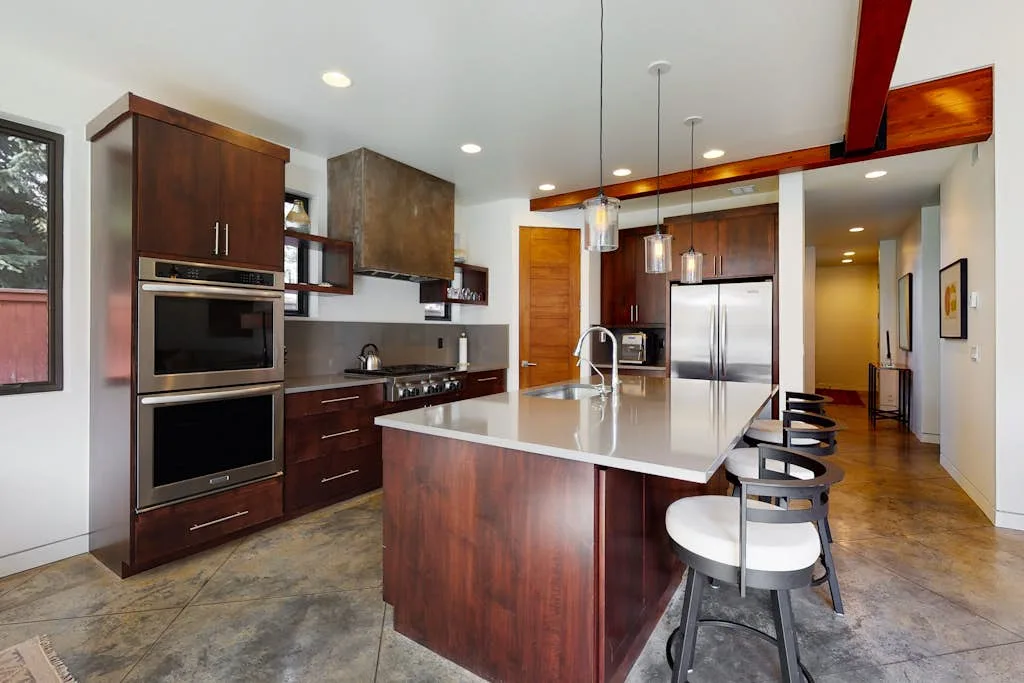Una cocina moderna con una isla grande y electrodomésticos de acero inoxidable.