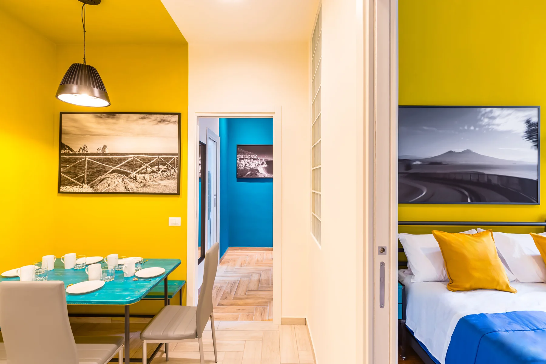 A bright dining area and bedroom are visible through an open doorway.