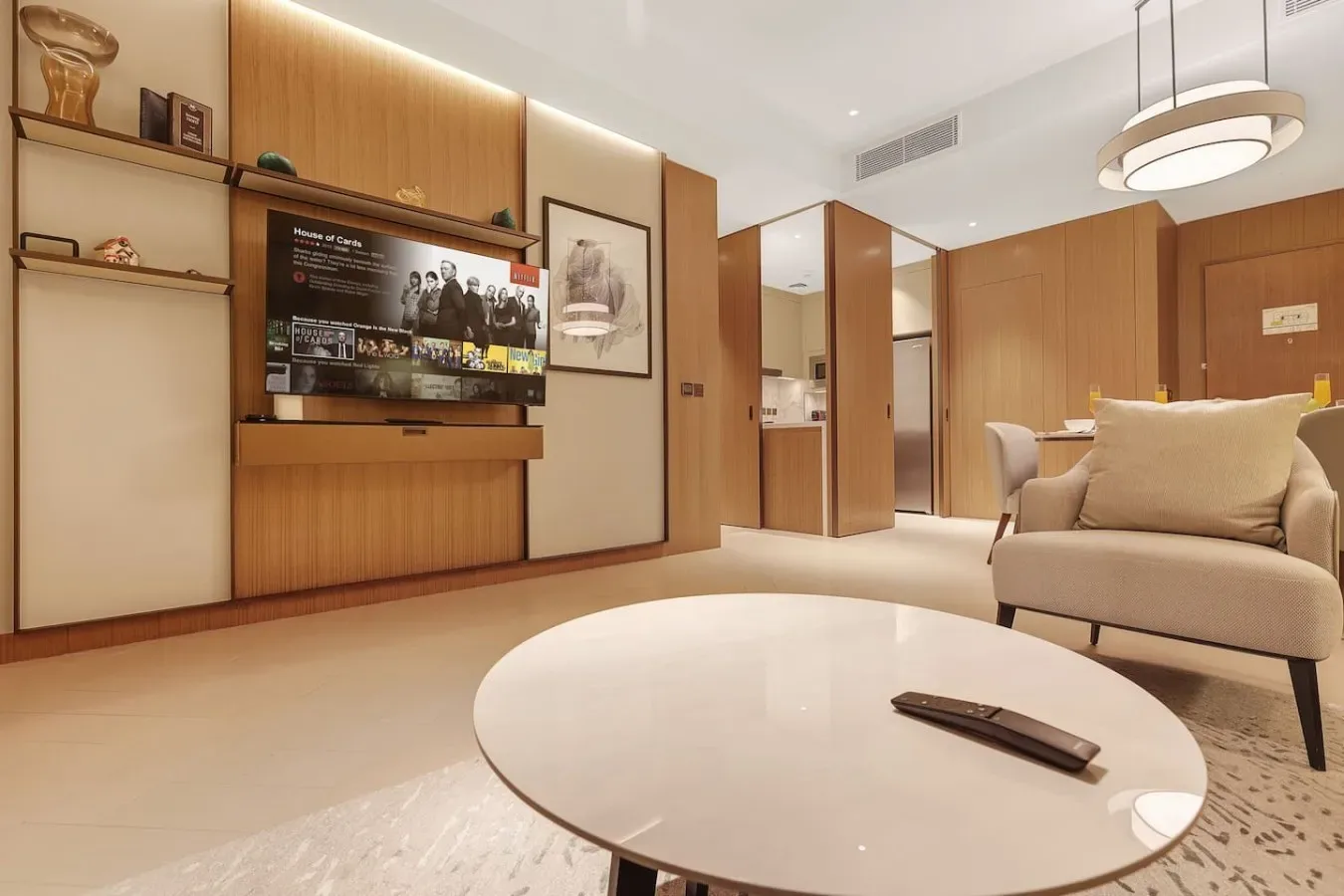 Una sala de estar con televisor, asientos y una mesa de centro redonda.