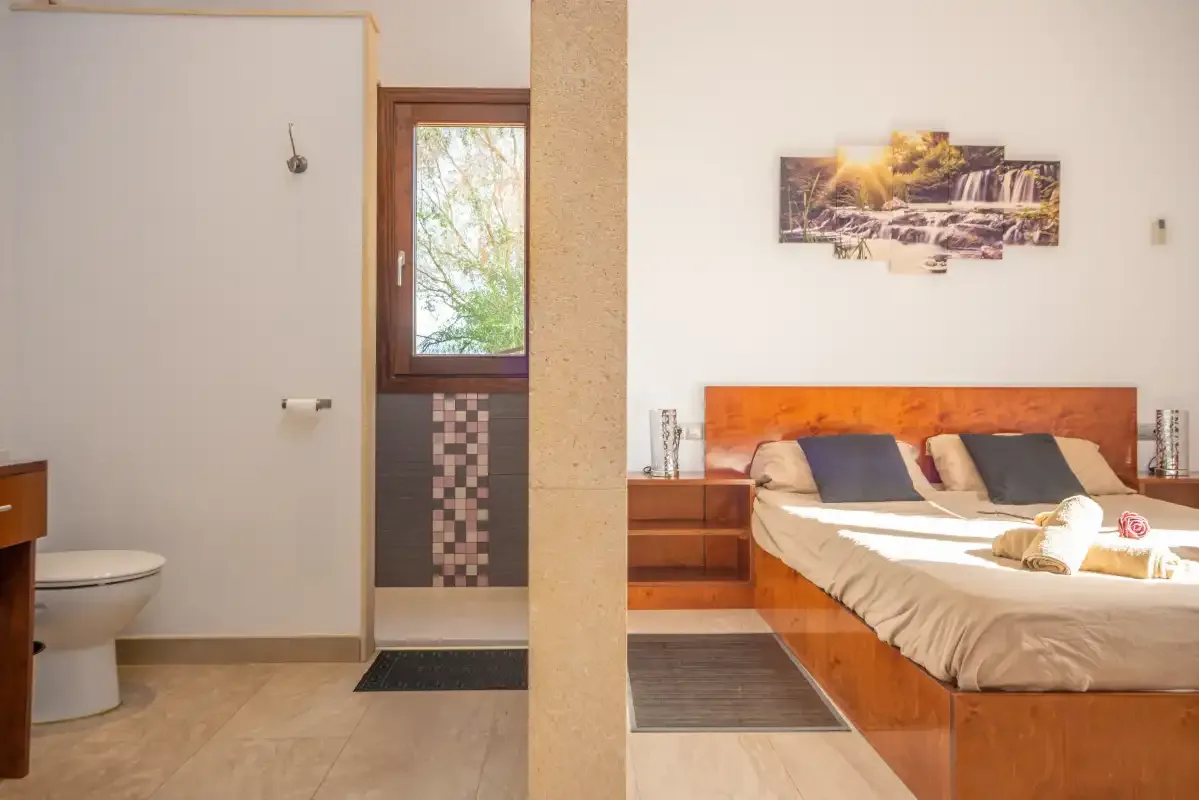 Un dormitorio con una cama y una zona de baño contigua.
