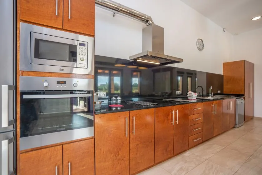 Una cocina moderna con armarios de madera y electrodomésticos de acero inoxidable.