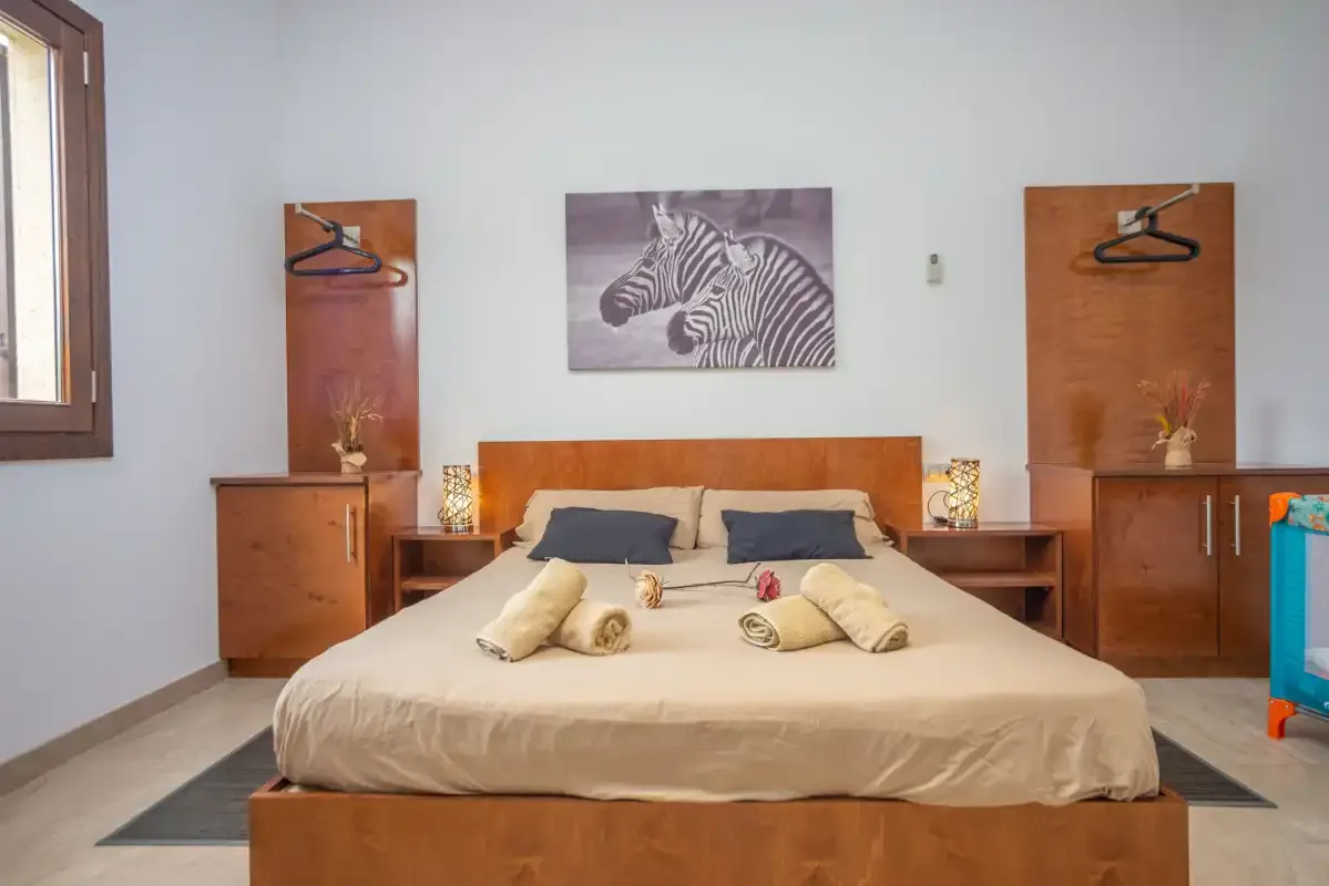 Un dormitorio con una cama y una imagen de una cebra sobre el cabecero.