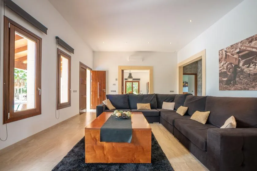Una sala luminosa con asientos oscuros alrededor de una mesa de centro de madera.