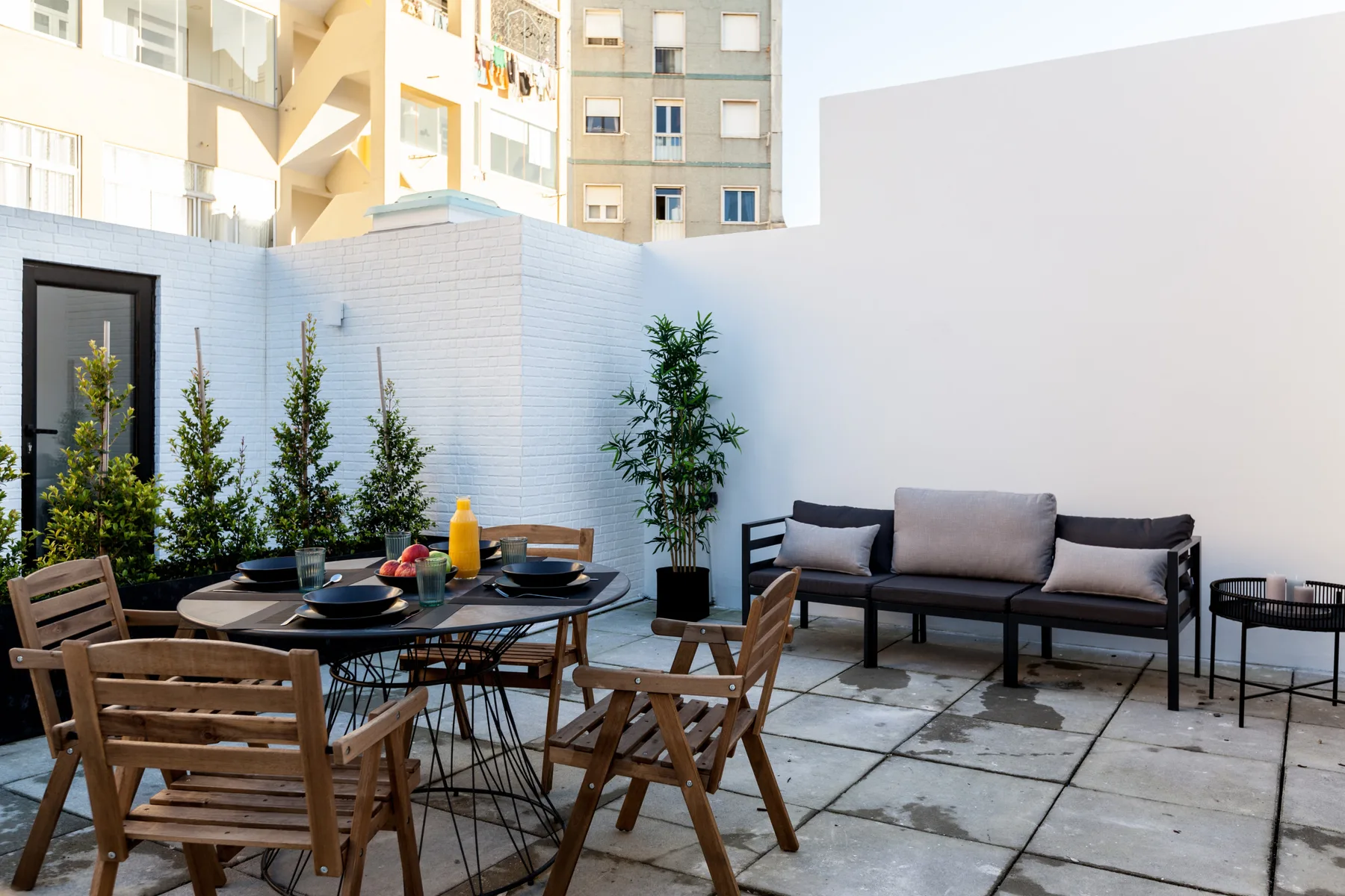 Un patio interior con asientos al aire libre y plantas en macetas.