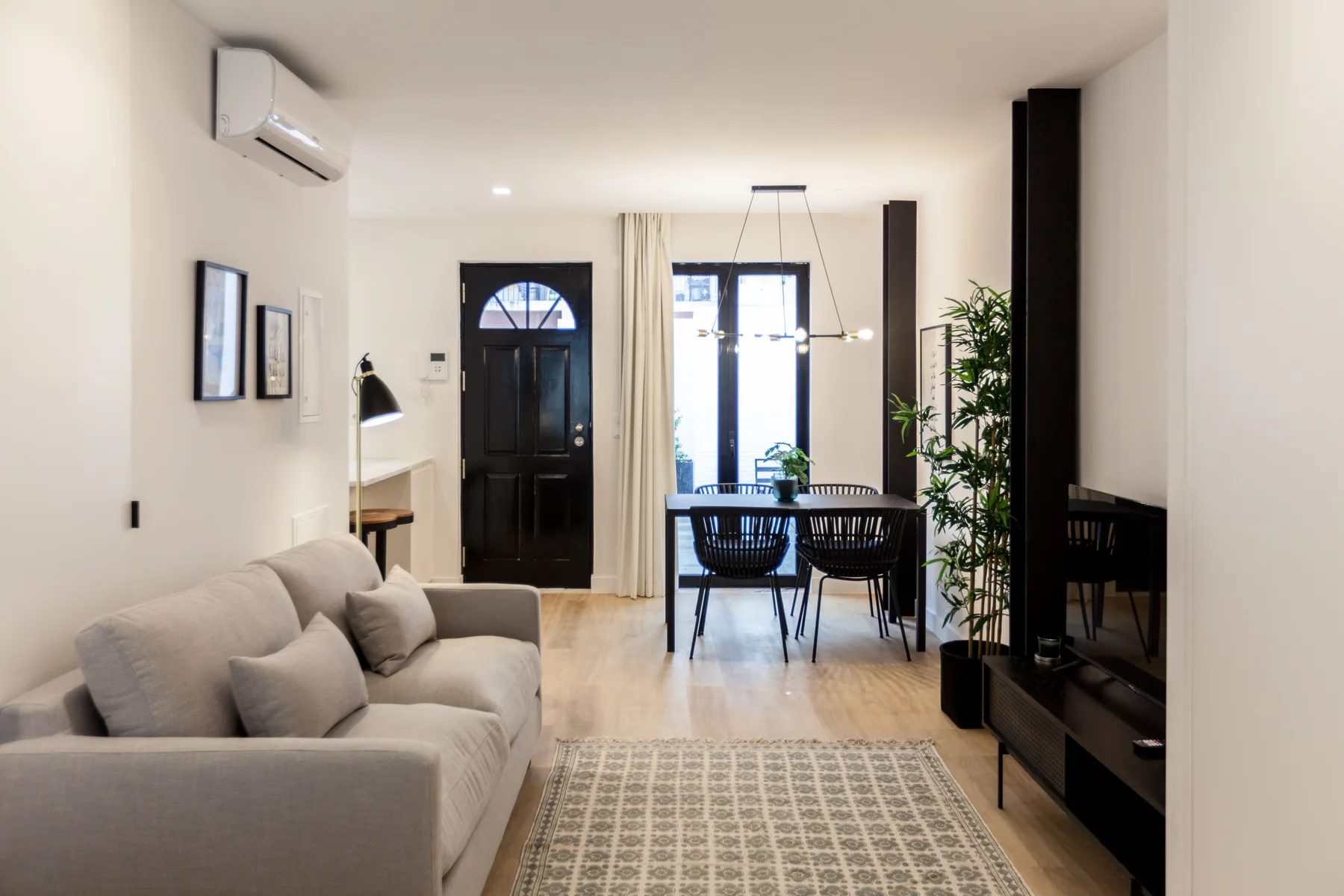 Una luminosa sala de estar y comedor con asientos, una mesa y una ventana amplia.