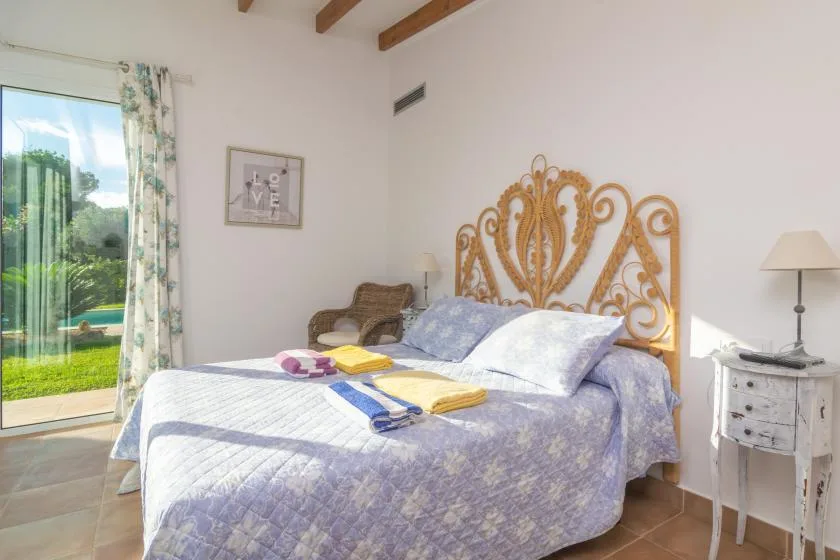 Un dormitorio con cama doble, ropa de cama estampada y un cabecero decorativo.