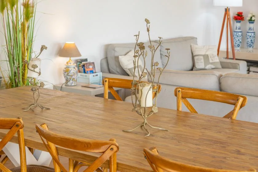 Una sala de estar y comedor con un sofá claro y una mesa de comedor de madera.