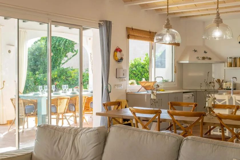 Un comedor luminoso y una cocina se abren a un patio mediante grandes puertas de vidrio.