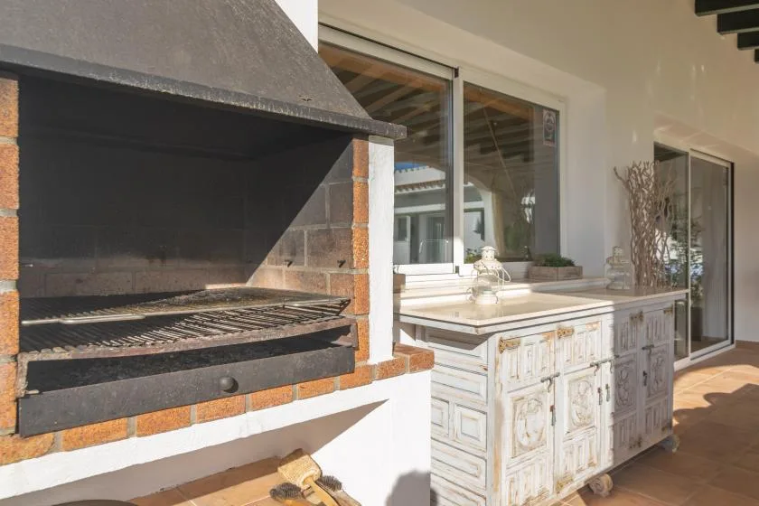 Una cocina exterior con una parrilla grande y una encimera.