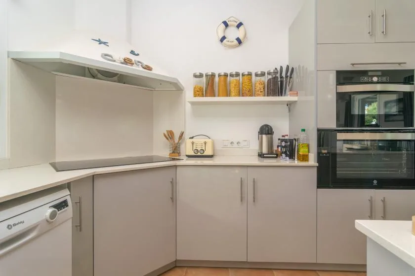 Una cocina moderna y luminosa con gabinetes claros y una encimera.