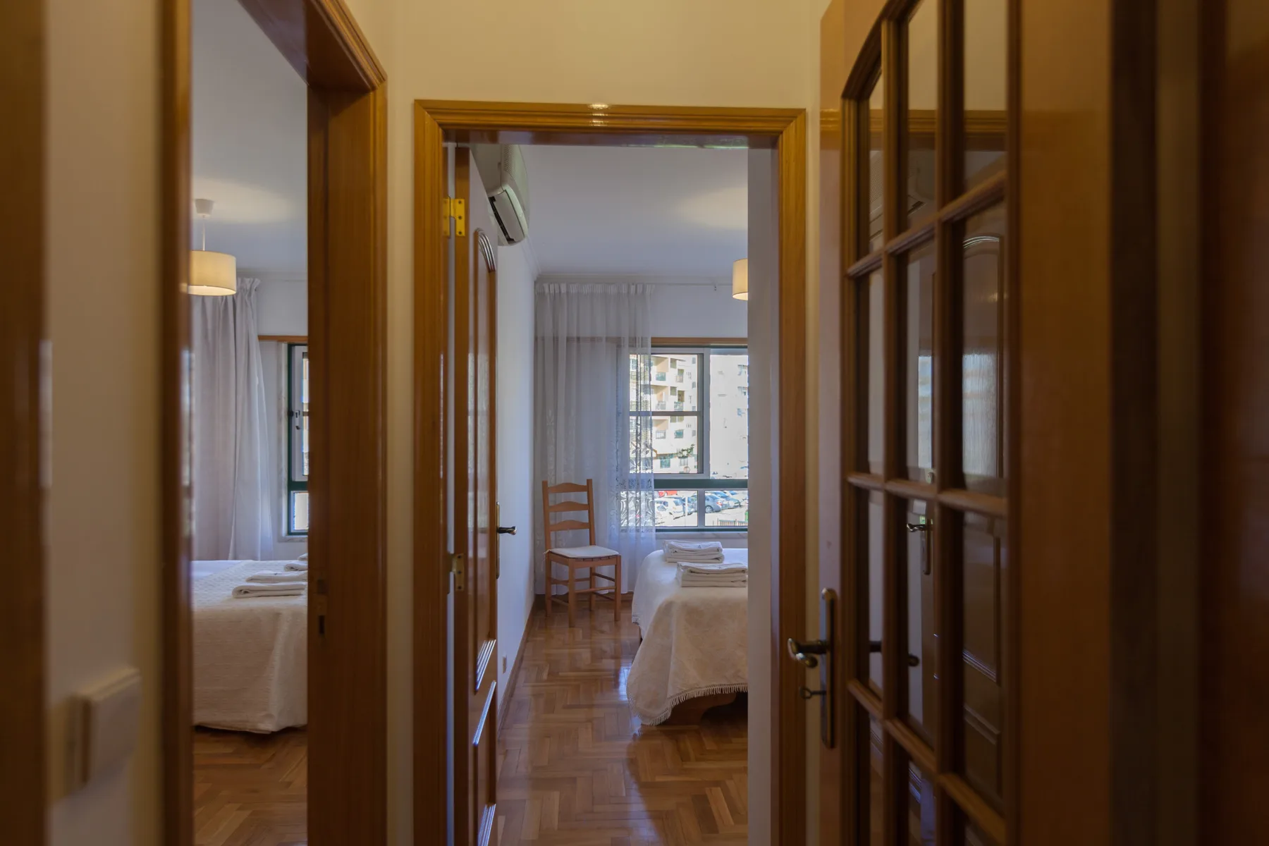 Un pasillo da a un dormitorio con una ventana y asientos.