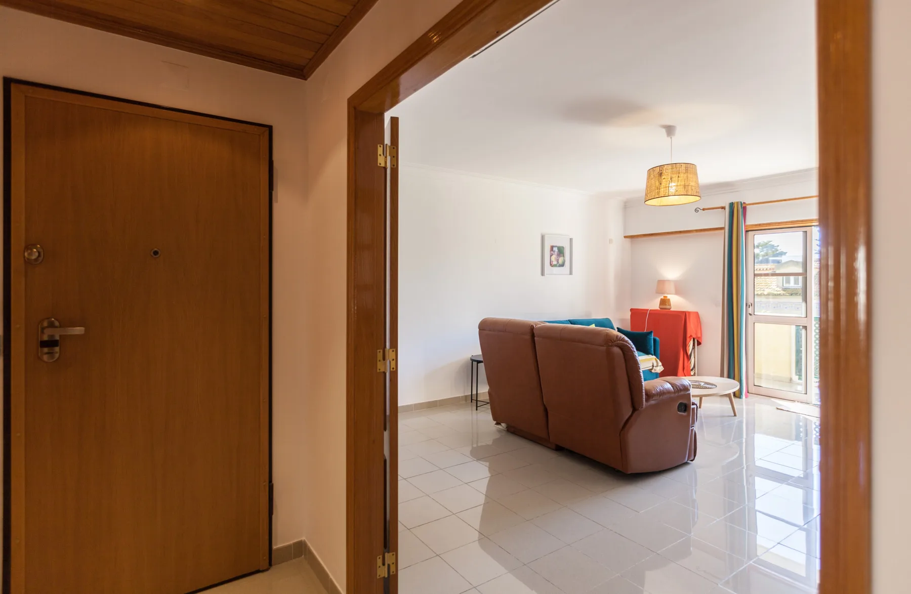 Sala de estar con asientos y una ventana junto a la entrada.