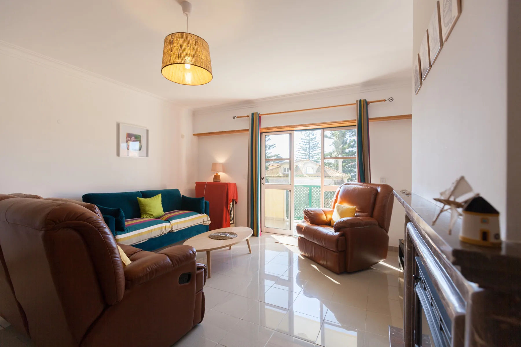 Sala de estar con asientos alrededor de una pequeña mesa de centro y puertas al balcón.