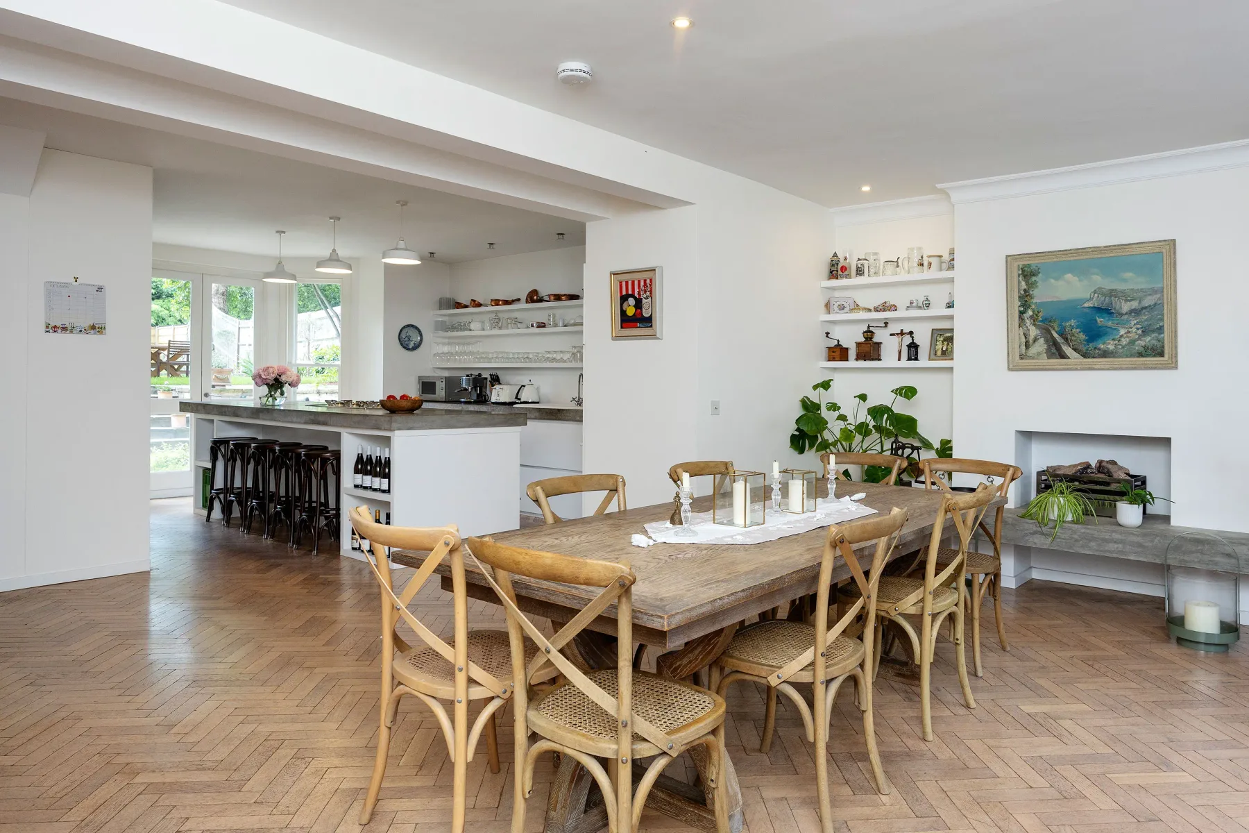 Un comedor con una mesa de madera y asientos junto a una cocina abierta.