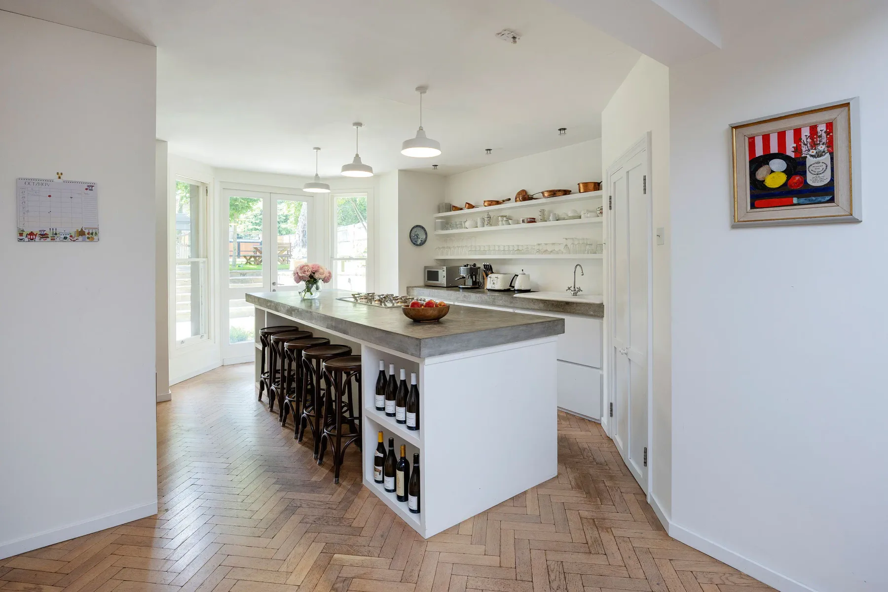 Una cocina luminosa con una isla central y asientos de barra.