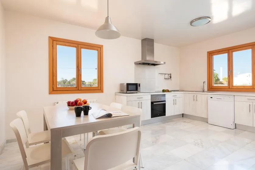 Una cocina luminosa con mesa de comedor y ventanas.