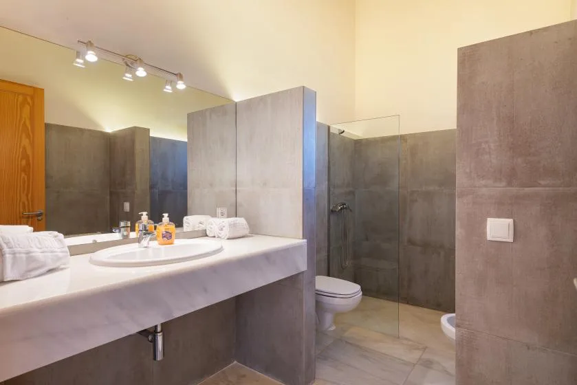 Un baño moderno con un tocador largo y una ducha de vidrio.