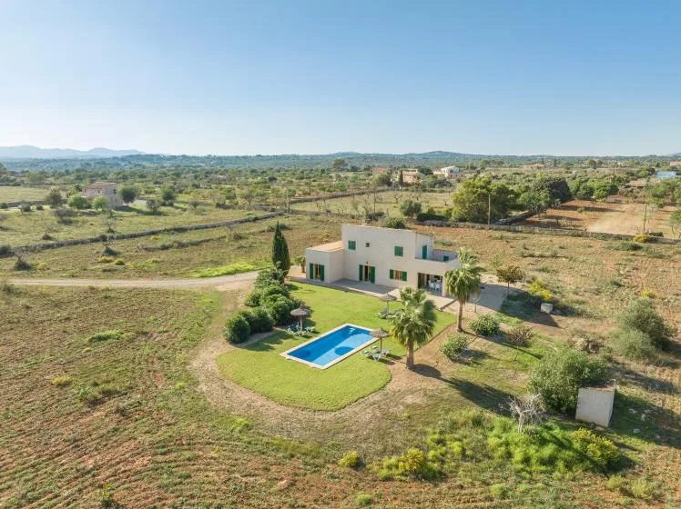 Una casa moderna con piscina se encuentra en medio del campo abierto.