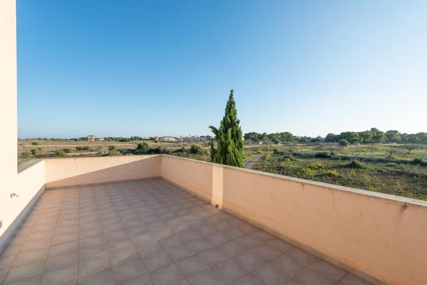 Una terraza embaldosada da a un paisaje rural bajo un cielo despejado.