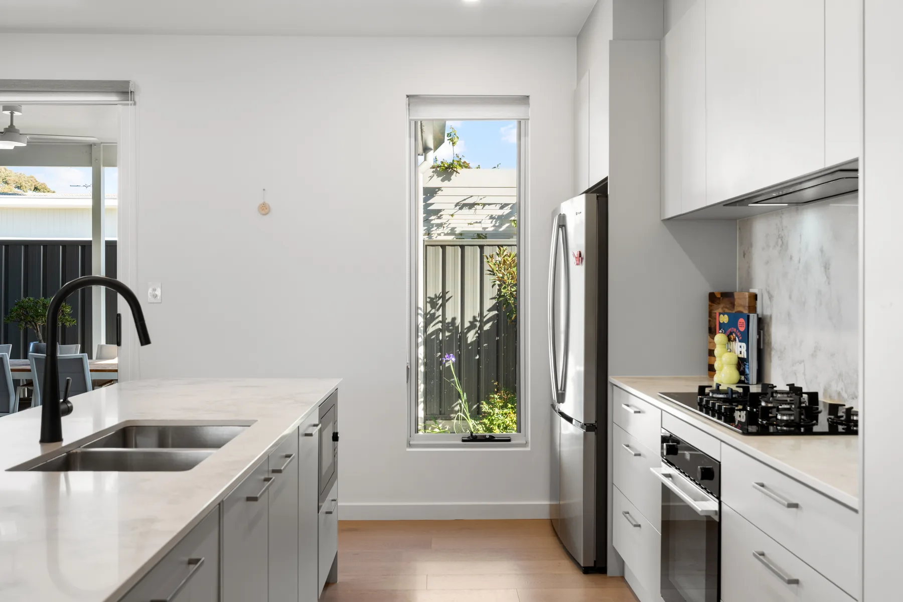 Una cocina moderna y luminosa con una isla grande, fregadero, placa de gas y horno.