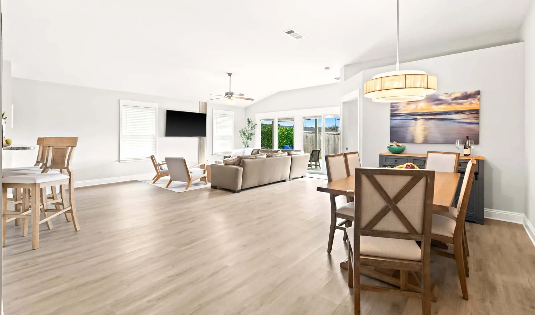 A bright open-plan living and dining area with seating and a dining table.