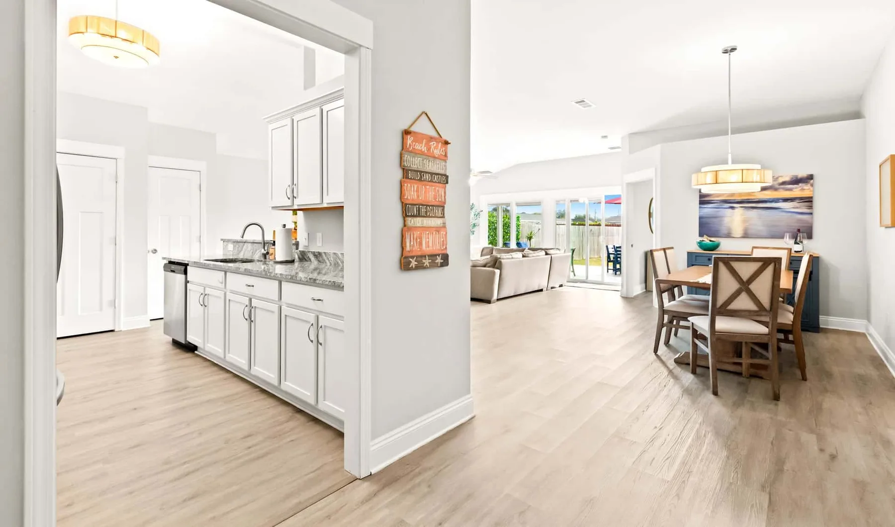 A bright open-plan kitchen and dining area with a table beside the kitchen.