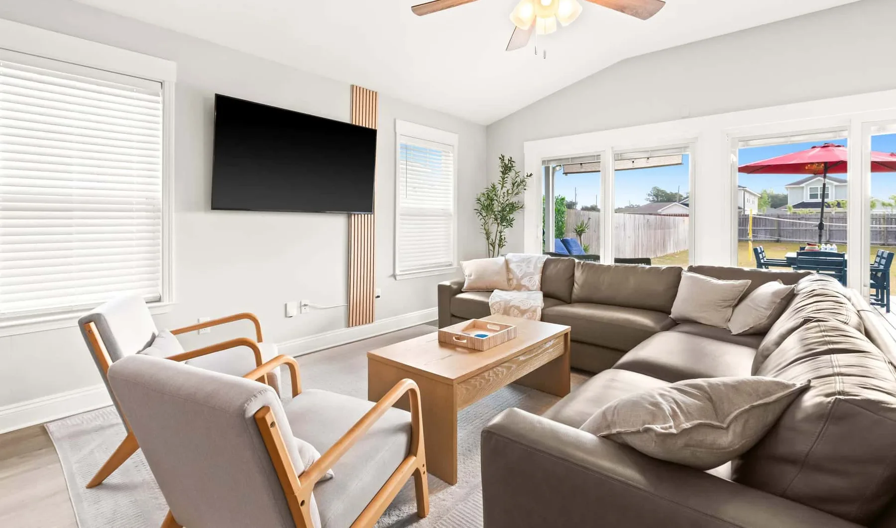 A living room with sectional seating, armchairs, and a television.